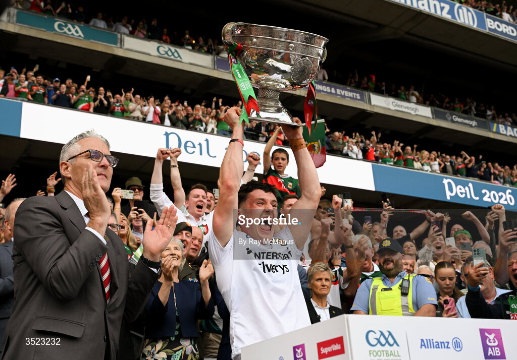 26 July 2026; Uachtarán Chumann Lúthchleas Gael Jarlath Burns applauds after presenting Mayo captain Jack Coyne, as he lifts the Sam Maguire after the GAA Football All-Ireland Senior Championship final match between Kerry and Mayo at Croke Park in Dublin. Photo by Ray McManus/Sportsfile