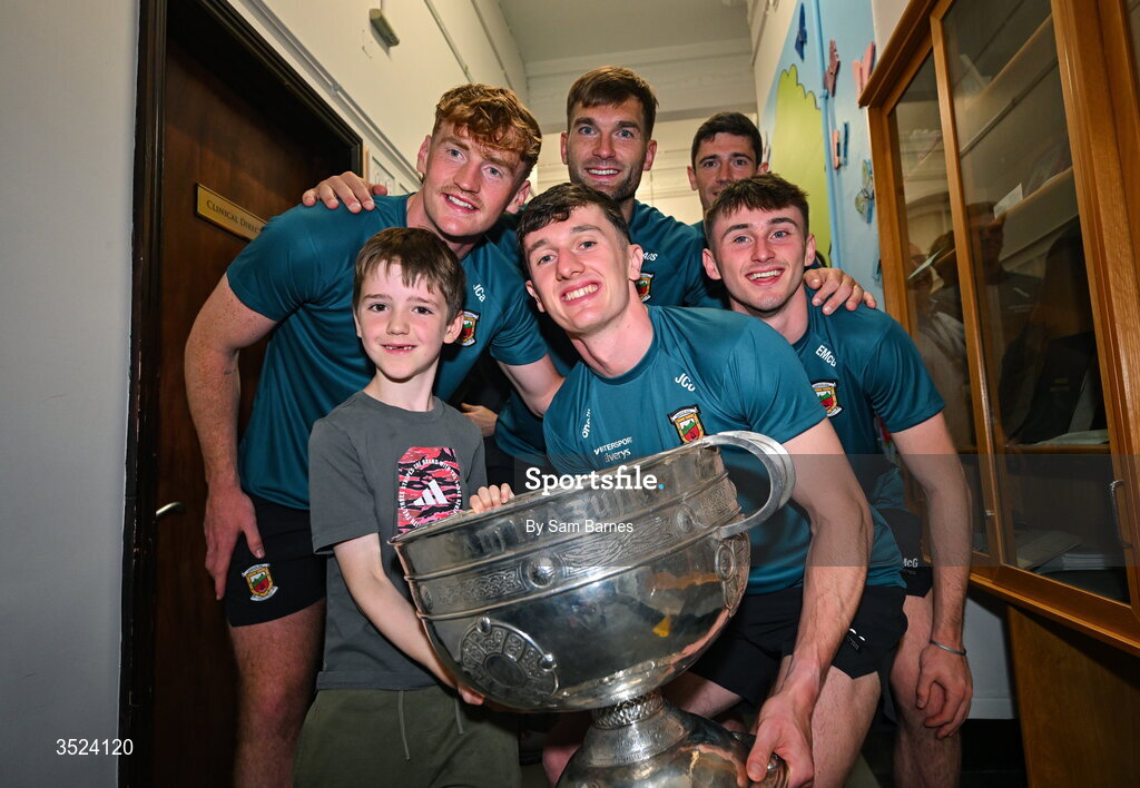27 July 2026; Mayo players, from left, Jack Carney, Jack Coyne, Aidan O'Shea and Eoin McGrea with supporter Nathaniel Leonard, aged 8, Loughshinny, Dublin at CHI Temple Street in Dublin after being crowned All-Ireland Senior Football champions following their victory over Kerry in the GAA All-Ireland Senior Football Championship final at Croke Park on Sunday. Photo by Sam Barnes/Sportsfile