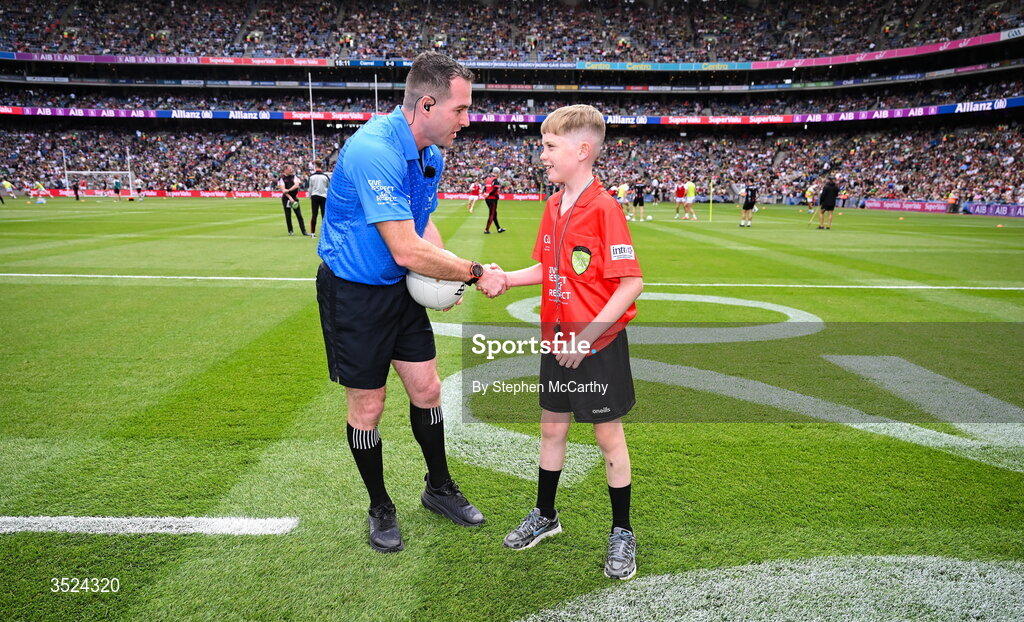26 July 2026; Darragh Ó Raifeartaigh, Gaelscoil Bhrian Bóroimhe, Sord, Baile Átha Cliath, presents the match ball to referee Martin McNally before the GAA Football All-Ireland Senior Championship final match between Kerry and Mayo at Croke Park in Dublin. Photo by Stephen McCarthy/Sportsfile Photo by Stephen McCarthy/Sportsfile