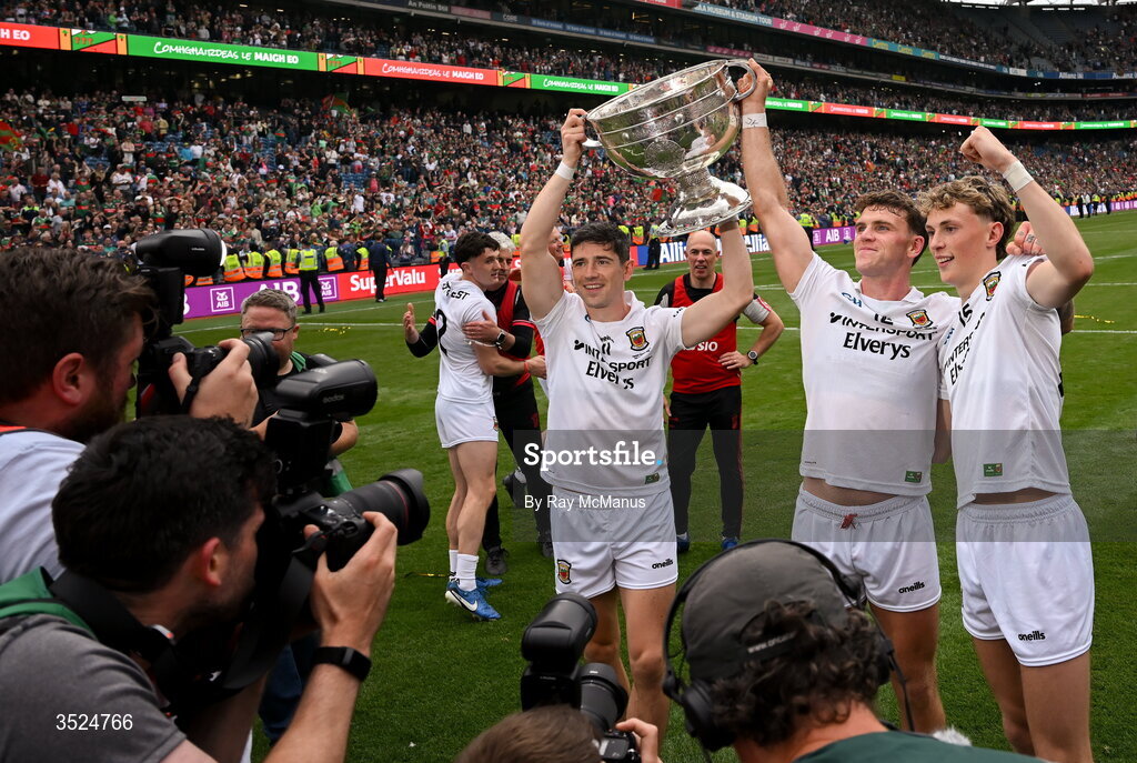 26 July 2026; Conor Loftus, Jordan Flynn, and Kobe McDonald of Mayo are surrounded by photographers and TV crews as they hold aloft the Sam Maguire after the GAA Football All-Ireland Senior Championship final match between Kerry and Mayo at Croke Park in Dublin. Photo by Ray McManus/Sportsfile