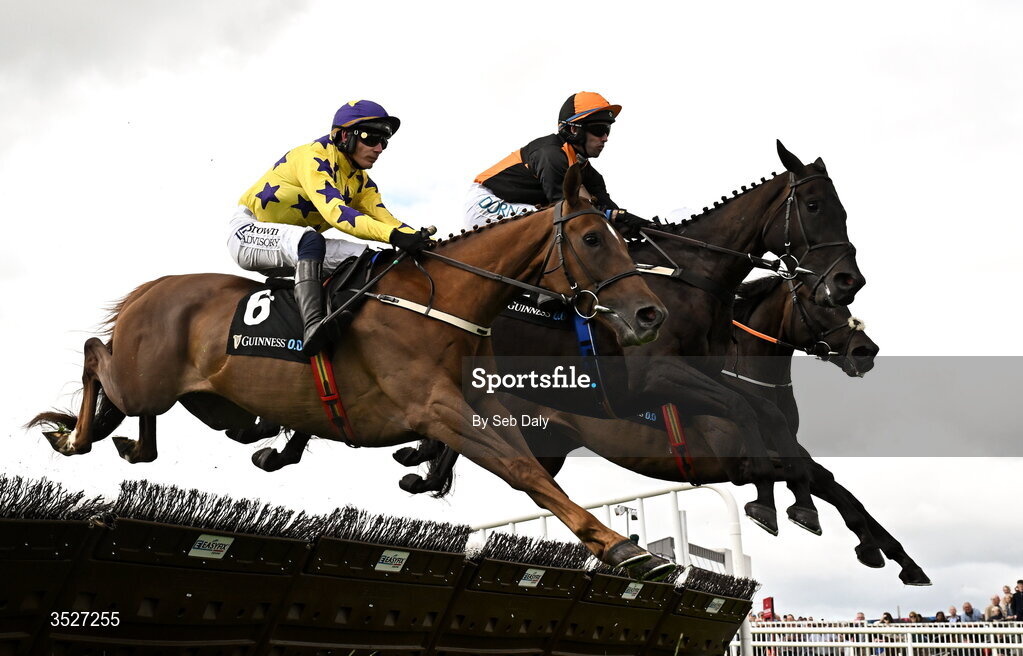 30 July 2026; Midnight Jet, centre, with Darragh O'Keeffe up, clear a hurdle on their way to winning the Guinness Novice Hurdle, from second place Roc Dino, left, with Paul Townend up, during day four of the Galway Races Summer Festival at Ballybrit Racecourse in Galway. Photo by Seb Daly/Sportsfile