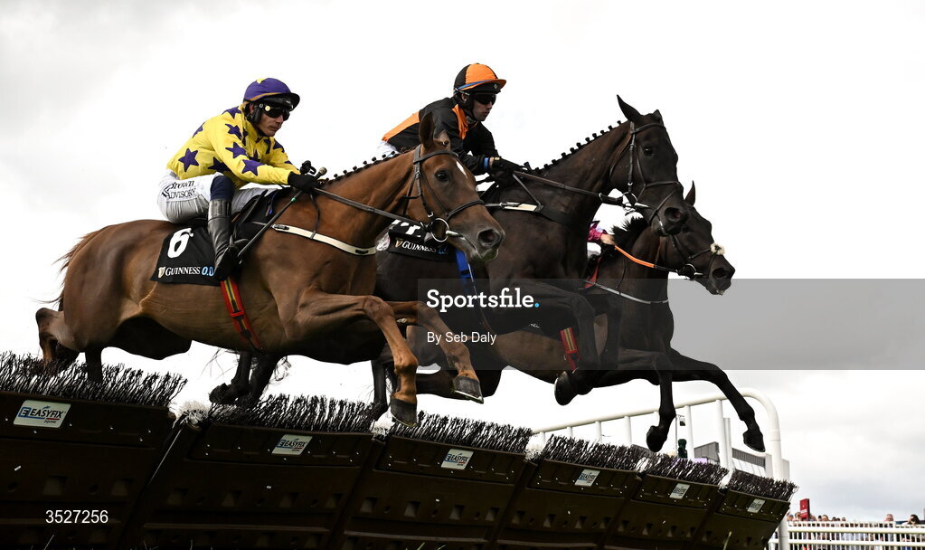 30 July 2026; Midnight Jet, centre, with Darragh O'Keeffe up, clear a hurdle on their way to winning the Guinness Novice Hurdle, from second place Roc Dino, left, with Paul Townend up, during day four of the Galway Races Summer Festival at Ballybrit Racecourse in Galway. Photo by Seb Daly/Sportsfile