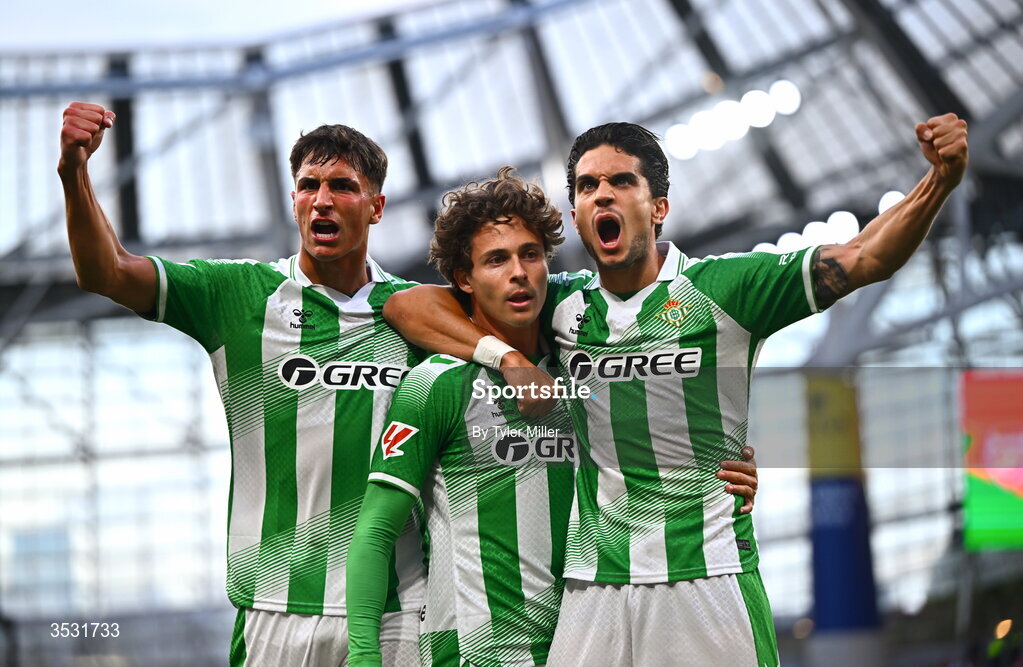 5 August 2026; Rodrigo Riquelme of Real Betis, centre, celebrates with teammates Facundo Bernal, left, and Marc Bartra after scoring his side's first goal during the pre-season friendly match between Arsenal and Real Betis at the Aviva Stadium in Dublin. Photo by Tyler Miller/Sportsfile