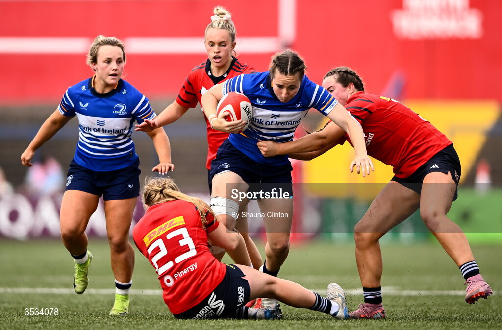 8 August 2026; Eve Higgins of Leinster is tackled by Munster players Ellen Boylan, left, and Katie Corrigan during the Vodafone Womens Interprovincial Championship Round 1 match between Munster and Leinster at Virgin Media Park in Cork. Photo by Shauna Clinton/Sportsfile