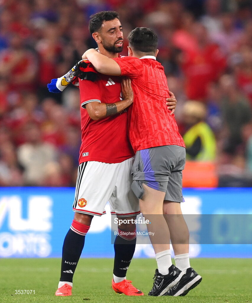 12 August 2026; A pitch invader hugs Bruno Fernandes of Manchester United during the pre-season friendly match between Manchester United and Leeds United at Croke Park in Dublin. Photo by Stephen McCarthy/Sportsfile
