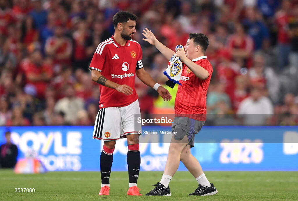 12 August 2026; A pitch invader runs to Bruno Fernandes of Manchester United during the pre-season friendly match between Manchester United and Leeds United at Croke Park in Dublin. Photo by Stephen McCarthy/Sportsfile