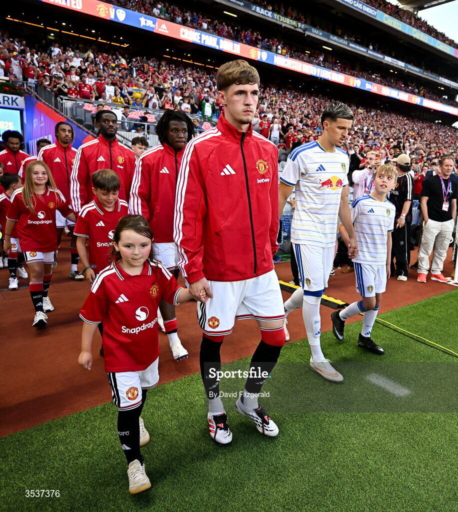 12 August 2026; Tyler Fletcher of Manchester United walks out with a mascot before the pre-season friendly match between Manchester United and Leeds United at Croke Park in Dublin. Photo by David Fitzgerald/Sportsfile