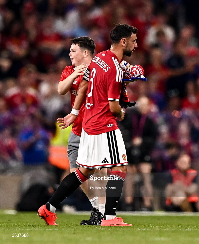 12 August 2026; A pitch invader hugs Bruno Fernandes of Manchester United during the pre-season friendly match between Manchester United and Leeds United at Croke Park in Dublin. Photo by Ben McShane/Sportsfile