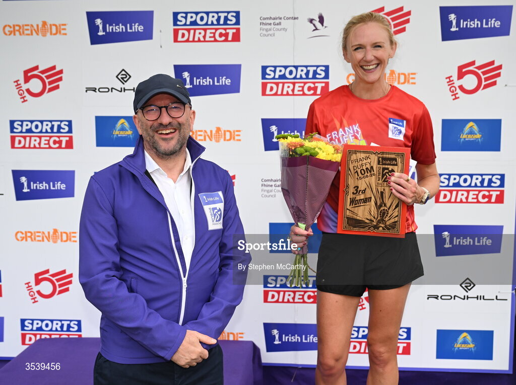 15 August 2026; Pamela Kirk of RaodRunners AC is presented with her third place prize by Brendan McEvoy, chief customer marketing society and innovation officer, Irish Life, during the 2026 Irish Life Frank Duffy 10 Mile, in the Phoenix Park, Dublin. Thousands of runners took part in the sold out Irish Life Frank Duffy 10 Mile, the second event in the 2026 Irish Life Dublin Race Series. Photo by Stephen McCarthy/Sportsfile