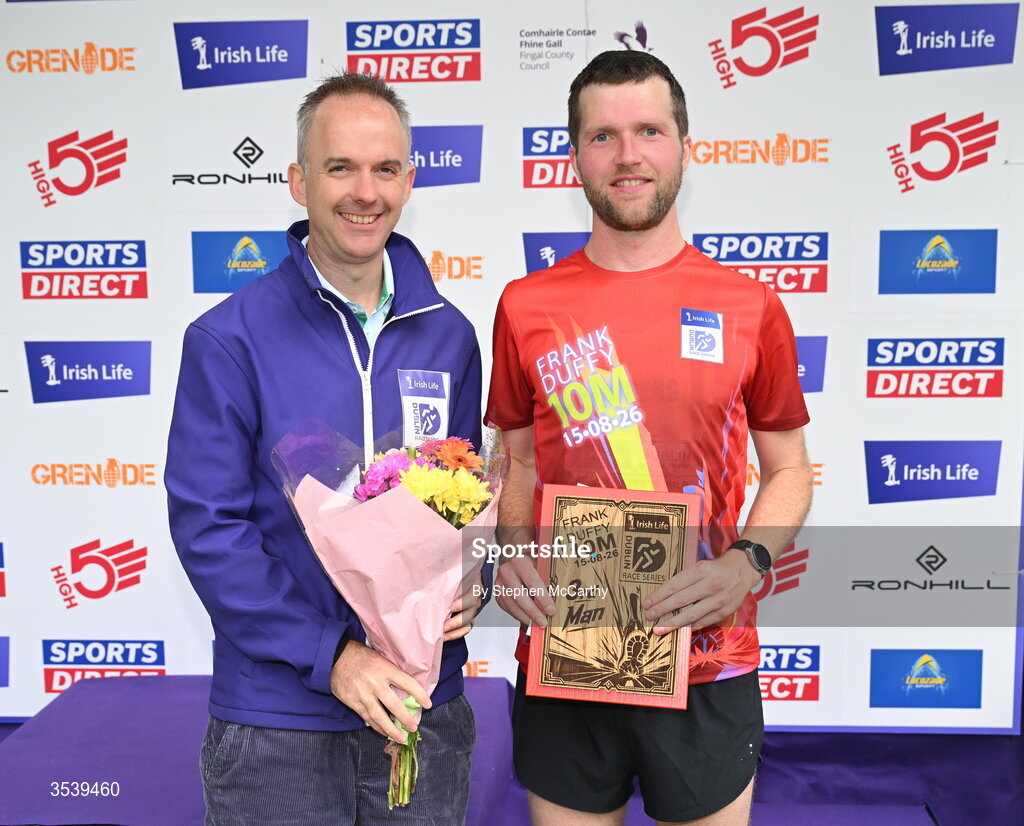 15 August 2026; Neil Johnston of Annadale Striders is presented with his third placed prize by Oisin O’Shaughnessy managing director employer solutions, Irish Life, during the 2026 Irish Life Frank Duffy 10 Mile, in the Phoenix Park, Dublin. Thousands of runners took part in the sold out Irish Life Frank Duffy 10 Mile, the second event in the 2026 Irish Life Dublin Race Series. Photo by Stephen McCarthy/Sportsfile