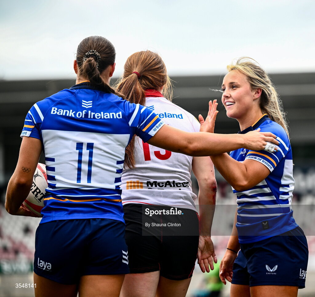 22 August 2026; Vicky Elmes Kinlan of Leinster, 11, is congratulated by team-mates after scoring her side's second try despite the efforts of Niamh Marley of Ulster during the Vodafone Womens Interprovincial Championship Round 3 match between Ulster and Leinster at Affidea Stadium in Belfast. Photo by Shauna Clinton/Sportsfile
