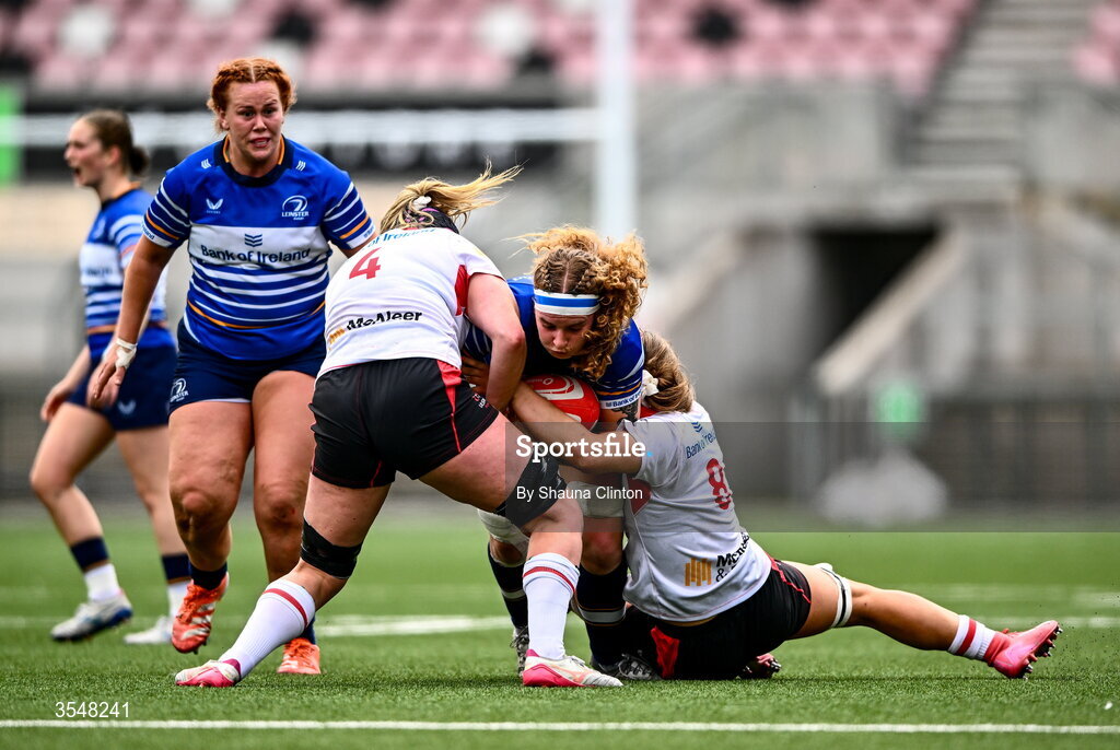 22 August 2026; Ruth Campbell of Leinster in action against Fiona Tuite-O'Sullivan, left, and Claire Boles of Ulster during the Vodafone Womens Interprovincial Championship Round 3 match between Ulster and Leinster at Affidea Stadium in Belfast. Photo by Shauna Clinton/Sportsfile