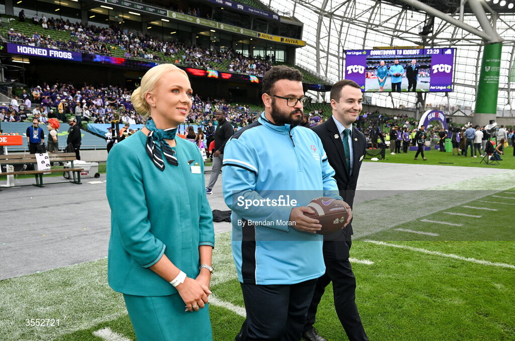 29 August 2026; Game Ball delivery by Special Olympics Ireland athlete Omer Teko with Aer Lingus cabin crew Jillian McDonald and Darragh McGrath before the 2026 Aer Lingus College Football Classic match between TCU and North Carolina at the Aviva Stadium in Dublin. Photo by Brendan Moran/Sportsfile