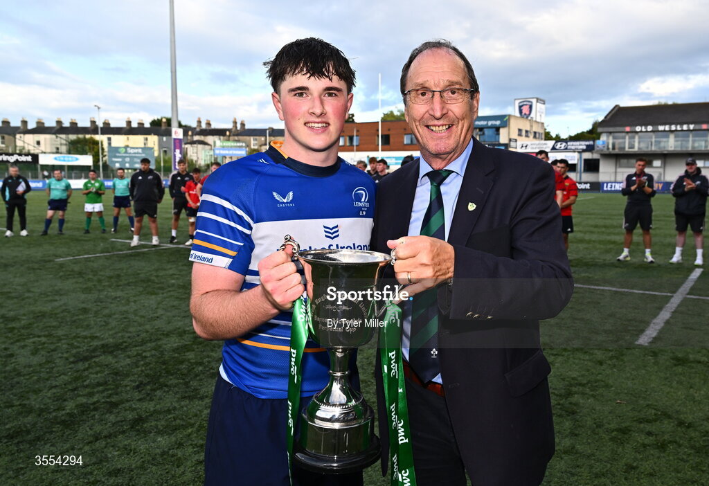 30 August 2026; Leinster captain Tom Martin is presented with the trophy by IRFU representative Barney McGonigle after the PwC U19 InterProvincial Championship match between Leinster and Munster at Energia Park in Dublin. Photo by Tyler Miller/Sportsfile