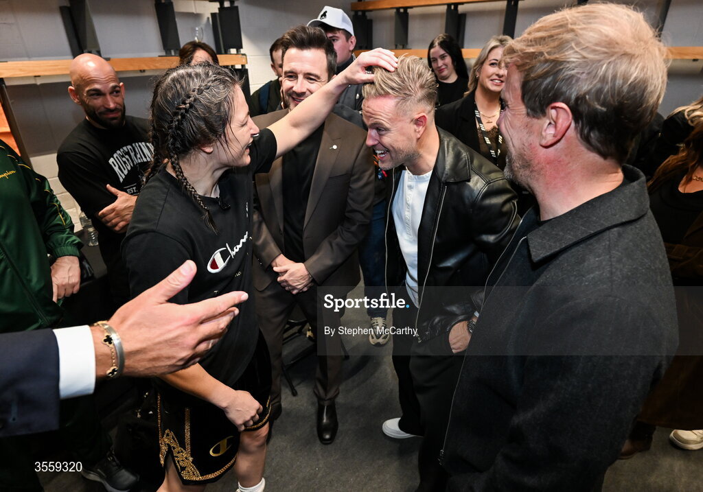 5 September 2026; Katie Taylor in her dressing room, with members of Westlife, from left, Shane Filan, Nicky Byrne and Kian Egan following her undisputed super lightweight championship fight victory over Flora Pili at the Once Upon A Time fight night in Croke Park, Dublin. Photo by Stephen McCarthy/Sportsfile