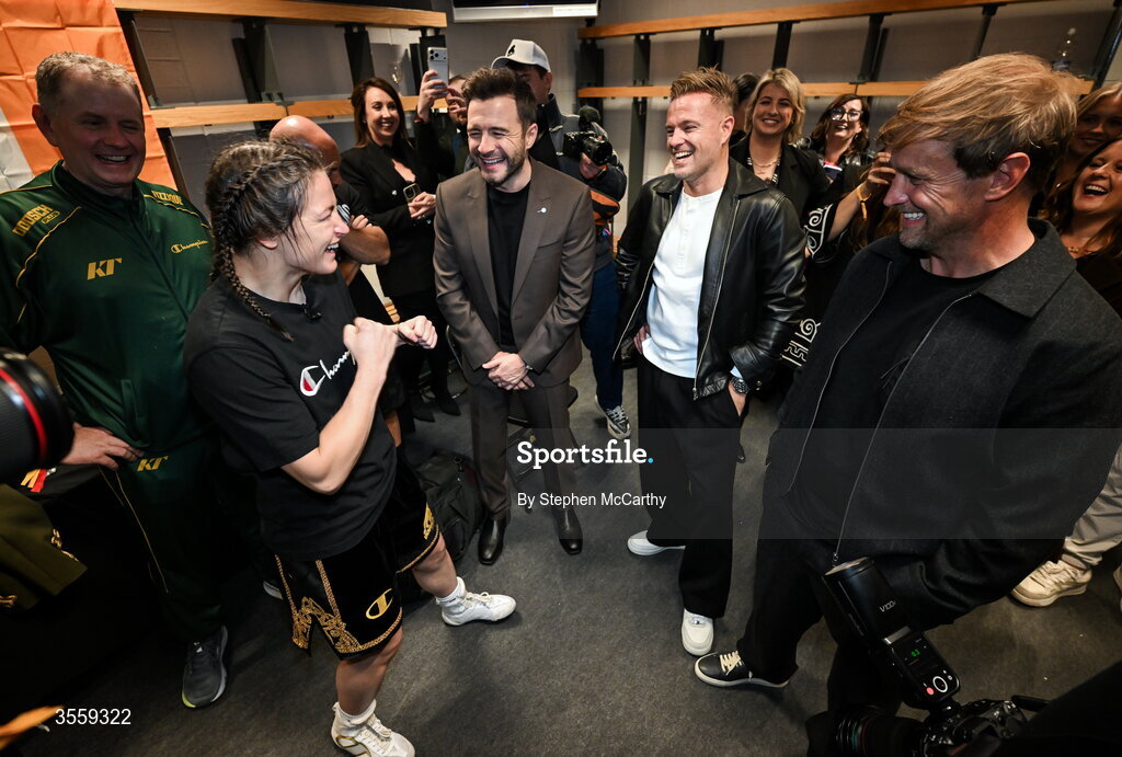 5 September 2026; Katie Taylor in her dressing room, with members of Westlife, from left, Shane Filan, Nicky Byrne and Kian Egan following her undisputed super lightweight championship fight victory over Flora Pili at the Once Upon A Time fight night in Croke Park, Dublin. Photo by Stephen McCarthy/Sportsfile