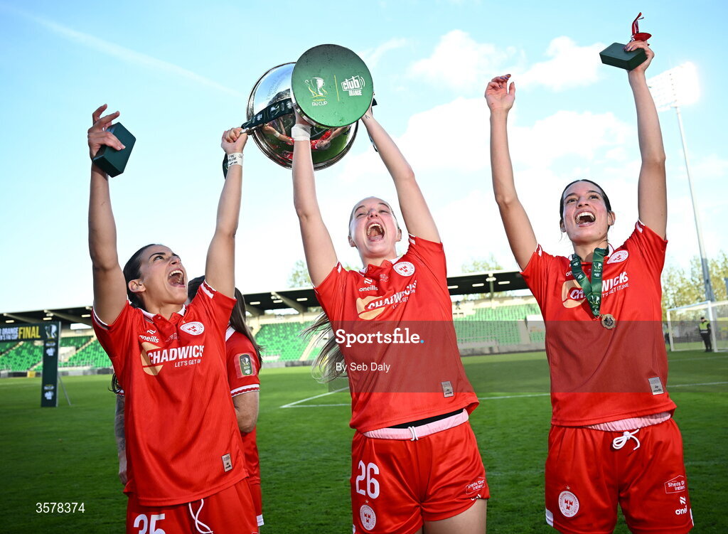 27 September 2026; Shelbourne players, from left, Olivia Damico, Brie Severns, and Isabella Flocchini celebrate with the cup after their side's victory in the 2026 Club Orange Women's FAI Cup final between Athlone Town and Shelbourne at Tallaght Stadium in Dublin. Photo by Seb Daly/Sportsfile