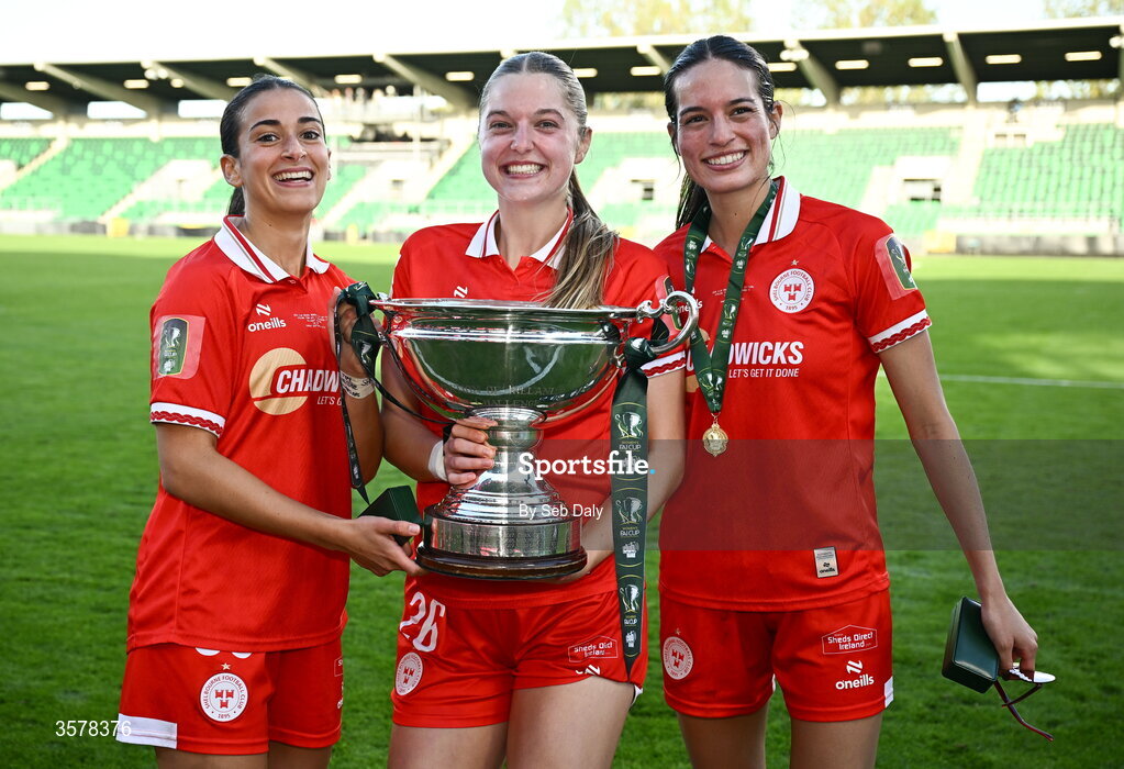27 September 2026; Shelbourne players, from left, Olivia Damico, Brie Severns, and Isabella Flocchini celebrate with the cup after their side's victory in the 2026 Club Orange Women's FAI Cup final between Athlone Town and Shelbourne at Tallaght Stadium in Dublin. Photo by Seb Daly/Sportsfile