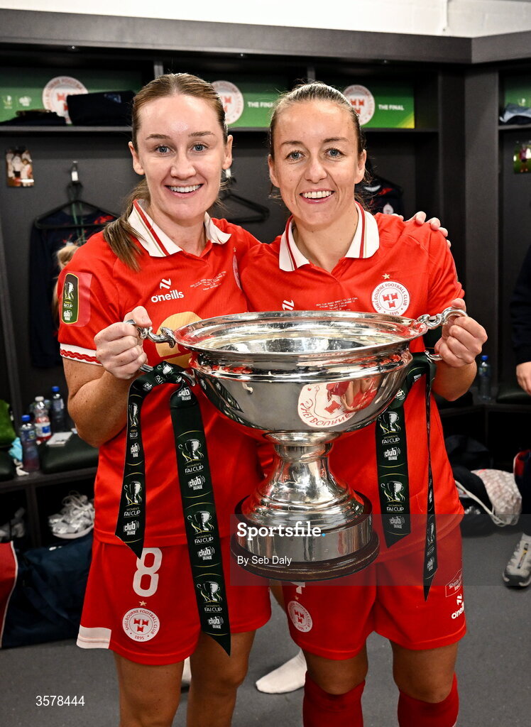 27 September 2026; Shelbourne players Rachel Graham, left, and Pearl Slattery with the trophy after their side's victory in the 2026 Club Orange Women's FAI Cup final between Athlone Town and Shelbourne at Tallaght Stadium in Dublin. Photo by Seb Daly/Sportsfile