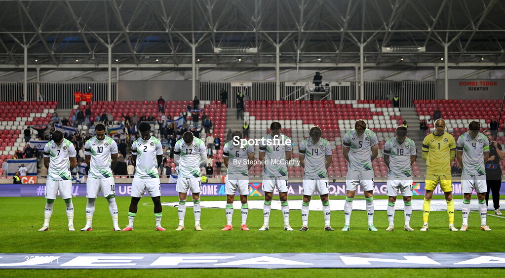 27 September 2026; The Republic of Ireland team, from left, Troy Parrott, Adam Idah, James Abankwah, Jack Moylan, Jayson Molumby, Liam Kitching, Conor Coventry, Jake O'Brien, Ryan Manning, goalkeeper Caoimhín Kelleher and captain Dara O'Shea, wearing black armbands in recognition for all the lives lost in the conflict in Gaza, bow their heads during the Israeli national anthem before the UEFA Nations League B match between Israel and the Republic of Ireland at Nagyerdei Stadion in Debrecen, Hungary.  Photo by Stephen McCarthy/Sportsfile