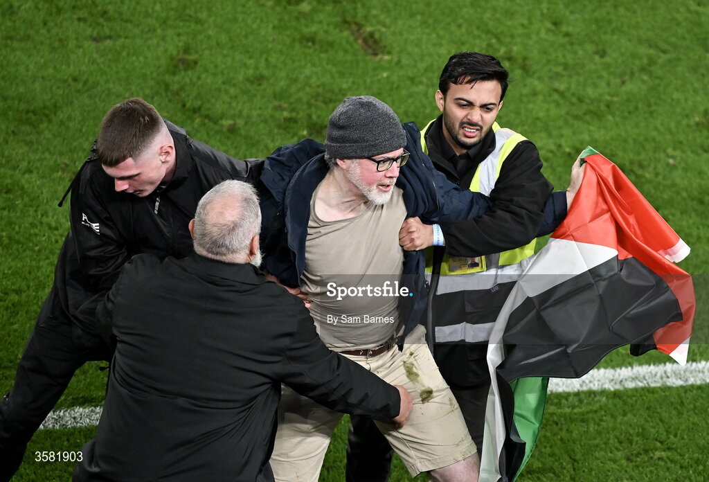 1 October 2026; A protestor with a Palestine flag is removed from the pitch during the UEFA Nations League B match between the Republic of Ireland and Austria at the Aviva Stadium in Dublin. Photo by Sam Barnes/Sportsfile