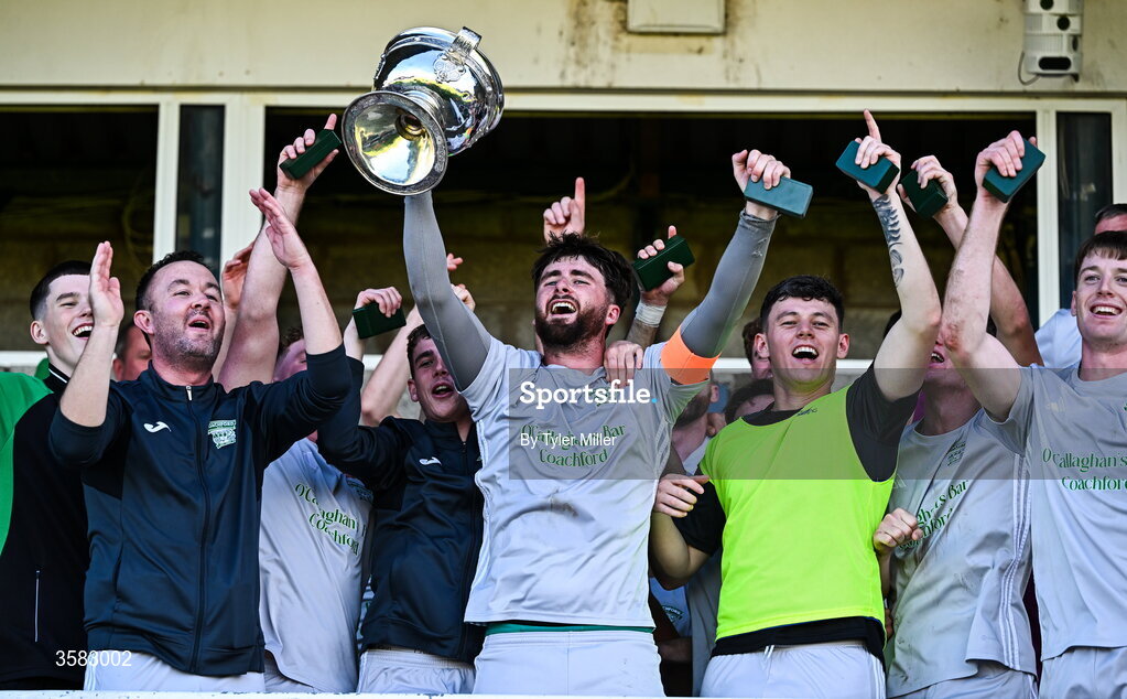 3 October 2026; Coachford captain Mark Murphy lifts the trophy alongside teammates after the FAI Junior Cup final between Coachford and Evergreen at Munster FA Turner's Cross Park in Cork. Photo by Tyler Miller/Sportsfile