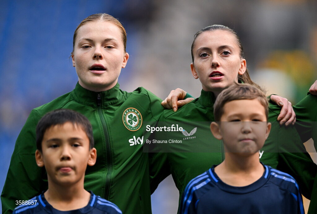 9 October 2026; Republic of Ireland players Emily Murphy, left, and Abbie Larkin stand for the playing of the national anthem before the 2027 FIFA Women’s World Cup qualifying round 1 play-off first leg match between Kazakhstan and the Republic of Ireland at Astana Arena in Kazakhstan. Photo by Shauna Clinton/Sportsfile