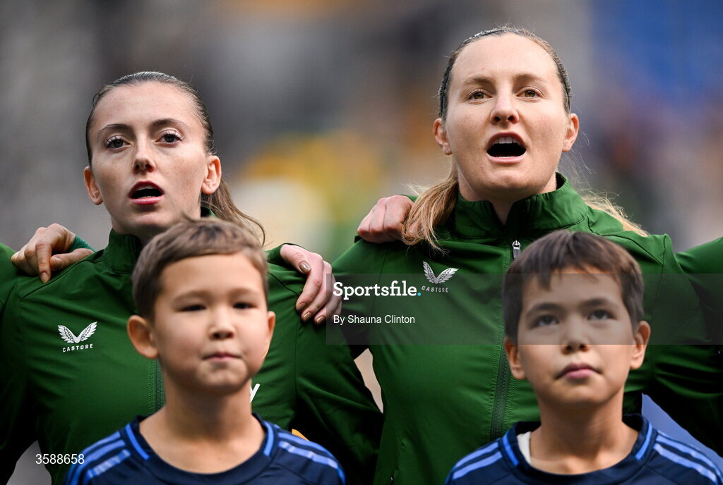 9 October 2026; Republic of Ireland players Abbie Larkin, left, and Kyra Carusa stand for the playing of the national anthem before the 2027 FIFA Women’s World Cup qualifying round 1 play-off first leg match between Kazakhstan and the Republic of Ireland at Astana Arena in Kazakhstan. Photo by Shauna Clinton/Sportsfile