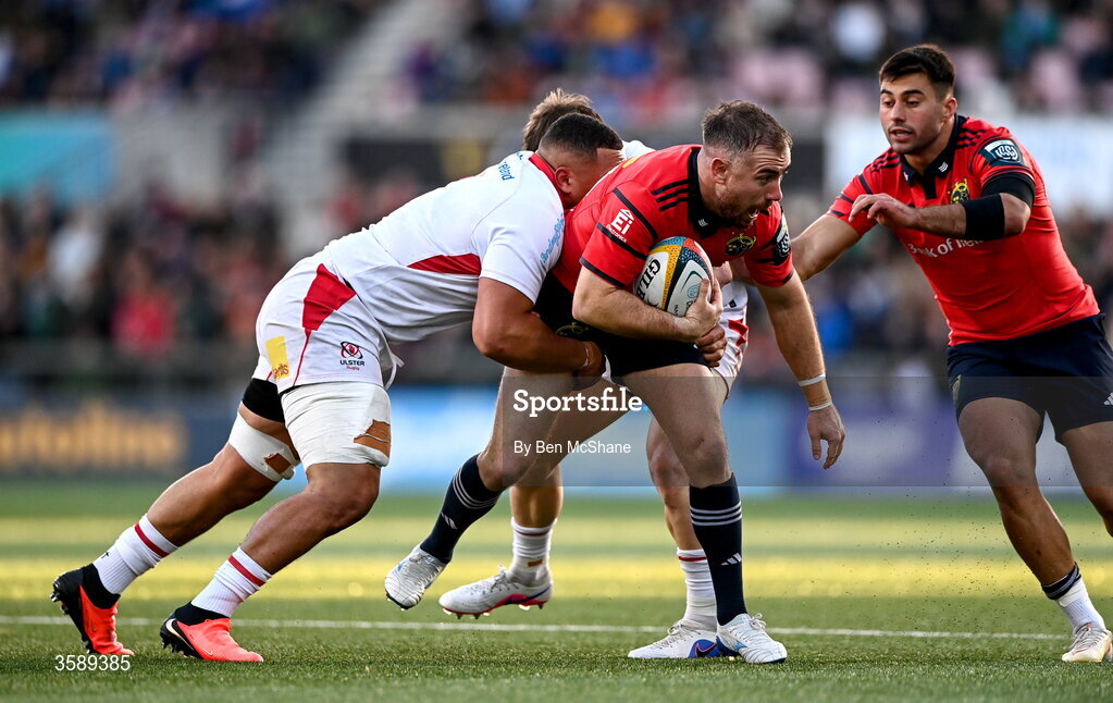 10 October 2026; JJ Hanrahan of Munster is tackled by Juarno Augustus, left, and Jamie Benson of Ulster during the United Rugby Championship match between Ulster and Munster at Affidea Stadium in Belfast. Photo by Ben McShane/Sportsfile
