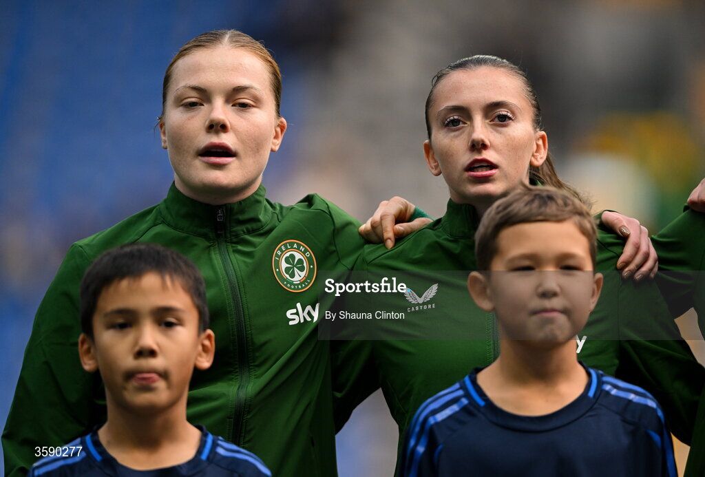 9 October 2026; Republic of Ireland players Emily Murphy, left, and Abbie Larkin stand for the playing of the national anthem before the 2027 FIFA Women’s World Cup qualifying round 1 play-off first leg match between Kazakhstan and the Republic of Ireland at Astana Arena in Kazakhstan. Photo by Shauna Clinton/Sportsfile