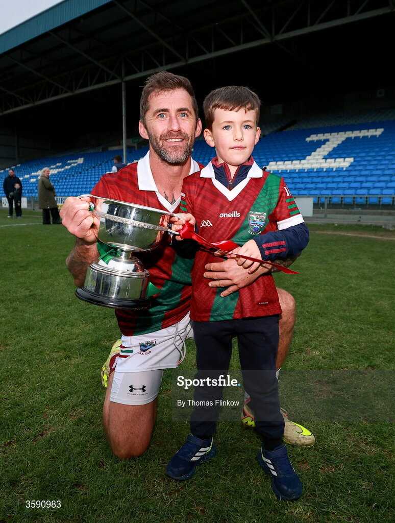 11 October 2026; Jason Moore of Portarlington celebrates with the cup with his son Leon, age 5, after the Laois County Senior Club Football Championship final match between Courtwood and Portarlington at Laois Hire O'Moore Park in Portlaoise, Laois. Photo by Thomas Flinkow/Sportsfile