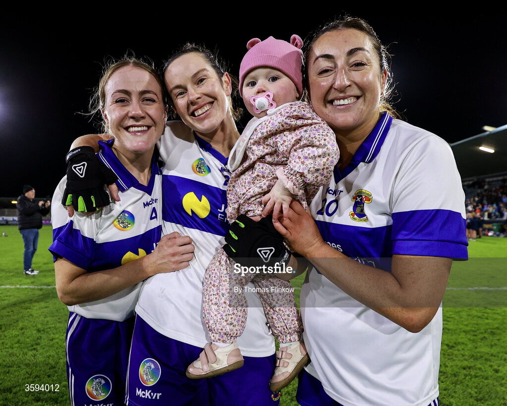 16 October 2026; Deirdre Johnston of St Vincent's, centre, celebrates with her daughter Caoimhe, aged 15 months, and teammates Lora Smith, left, and Ciara O Leary after the PTSB Dublin Senior Club Hurling final match between St Vincent's and St Jude's at Parnell Park in Dublin. Photo by Thomas Flinkow/Sportsfile