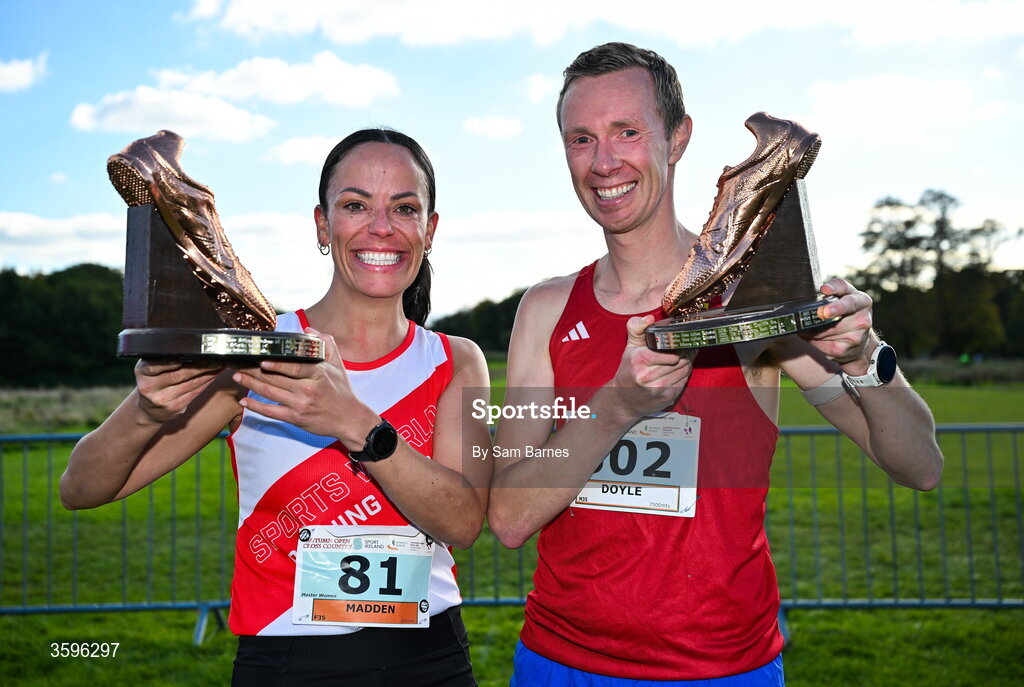 18 October 2026; Lisa Madden of Sportsworld AC, Dublin, left, and Sean Doyle of Cork City AC with the Jim McNamara Trophies after winning the Master Women 6000m and Master Men 7500m  during the Autumn Open Cross Country International at the Sport Ireland Campus in Dublin. Photo by Sam Barnes/Sportsfile
