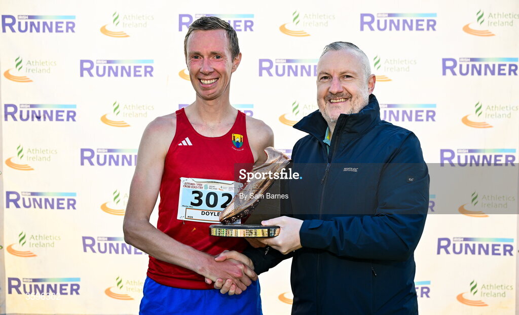 18 October 2026; Sean Doyle of Cork City AC is presented with the Jim McNamara Trophy by Shane McNamara after winning  the Master Men 7500m during the Autumn Open Cross Country International at the Sport Ireland Campus in Dublin. Photo by Sam Barnes/Sportsfile