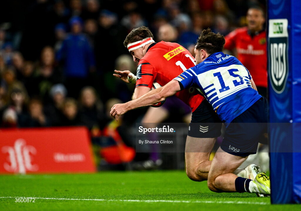 24 October 2026; Shane Daly of Munster scores his side's opening try despite the tackle of Hugo Keenan of Leinster during the United Rugby Championship match between Leinster and Munster at the Aviva Stadium in Dublin. Photo by Shauna Clinton/Sportsfile