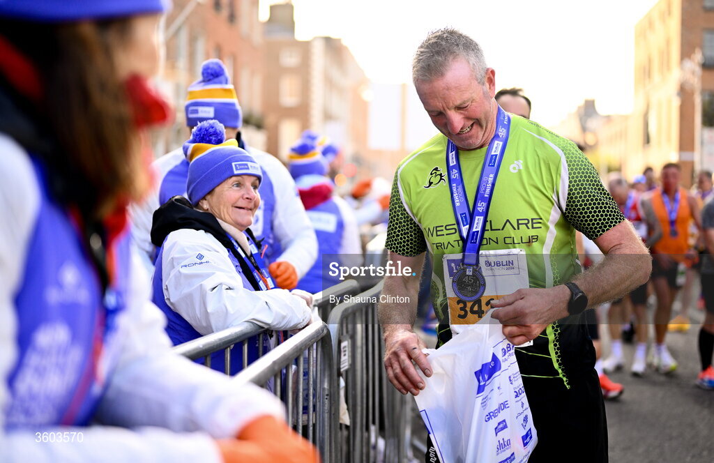 25 October 2026; Participants collect goody bags from volunteers after the 2026 Irish Life Dublin Marathon. Photo by Shauna Clinton/Sportsfile