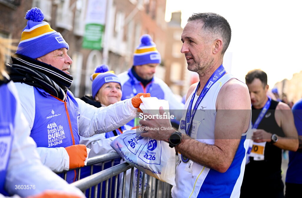 25 October 2026; Participants collect goody bags from volunteers after the 2026 Irish Life Dublin Marathon. Photo by Shauna Clinton/Sportsfile