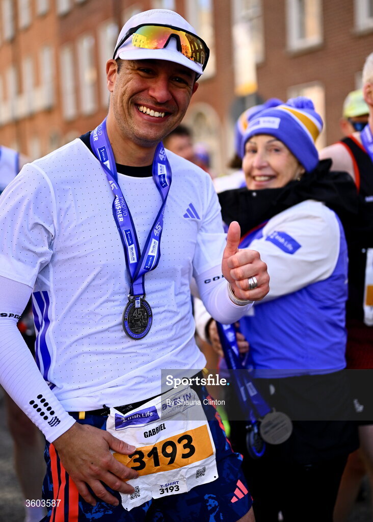 25 October 2026; Gabriel Mello De Souza with volunteers after the 2026 Irish Life Dublin Marathon. Photo by Shauna Clinton/Sportsfile