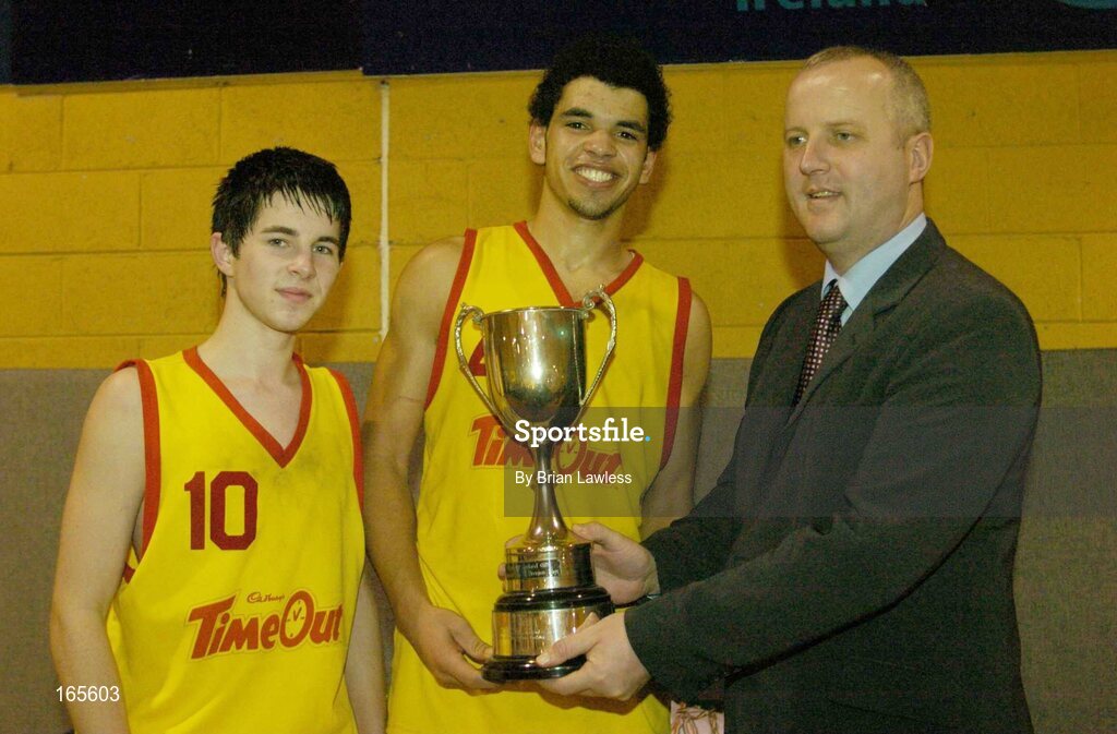 3 February 2005; Martin Hehir, right, Schools Development Officer, Basketball Ireland, presents St. Fintan's Co-captains Erin Grace, left, and Aaron Westbrooks with the cup after victory in the final. All-Ireland Schools Cup, U19 A Boys Final, St. Fintan's, Sutton, Dublin v Calasanctius, Oranmore, Galway, National Basketball Arena, Tallaght, Dublin. Picture credit; Brian Lawless / SPORTSFILE