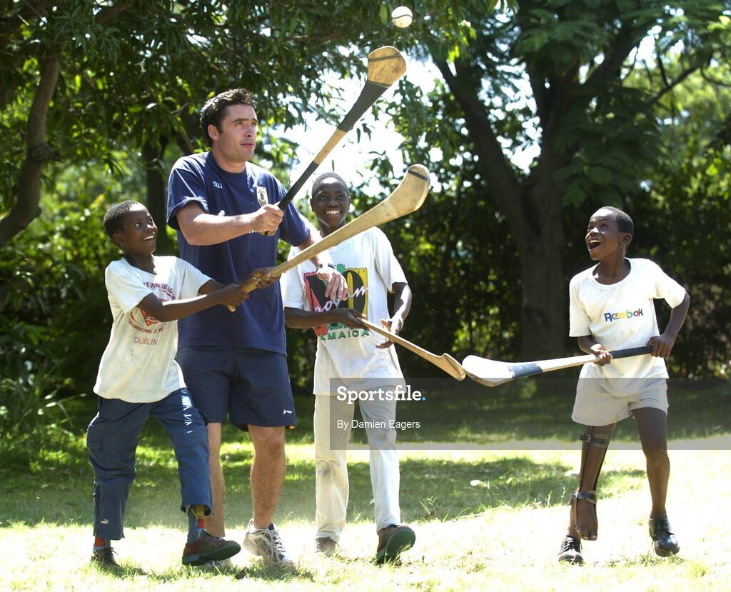 25 February 2005; Galway's Alan Kerins teaches some hurling to local children Mumbua, left, Namatimbo and Simona, right. Cheshire home for the physically challenged children, Mongu, Zambia. Picture credit; Damien Eagers / SPORTSFILE