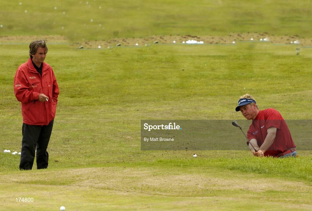 23 July 2004; Darren Clarke plays from a bunker on the practice ground under the supervision of his mental coach, Belgian, Jos Vanstiphout before the start of the second round. Nissan Irish Open Golf Championship, County Louth Golf Club, Baltray, Co. Louth. Picture credit; Matt Browne / SPORTSFILE