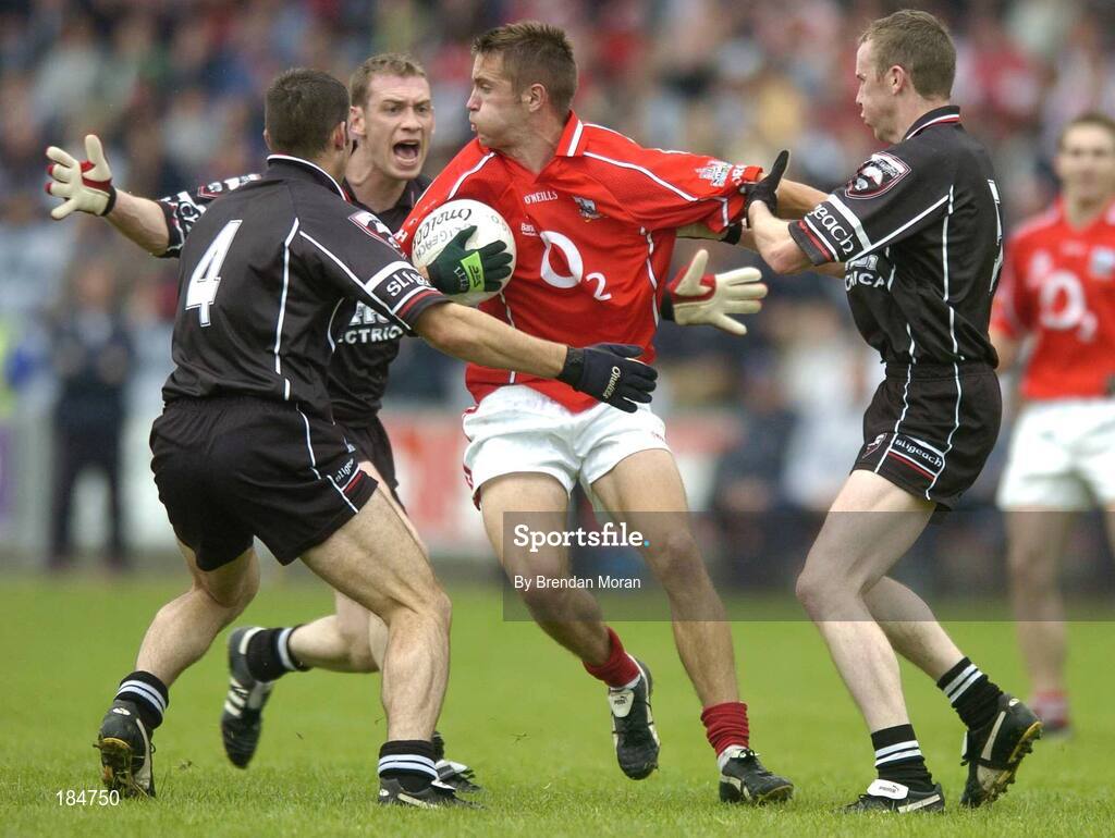 30 July 2005; Kevin McMahon, Cork, is tackled by Brendan Phillips (4), Noel McGuire and Padraig Doohan, right, Sligo. Bank of Ireland Football Championship qualifiers, Round 4. Cork v Sligo, O'Moore Park, Portlaoise, Co. Laois. Picture credit; Brendan Moran / SPORTSFILE