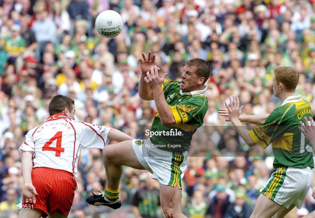25 September 2005; Dara O'Cinneide supported by team-mate Colm Cooper, left, Kerry, in action against Michael McGee, Tyrone. Bank of Ireland All-Ireland Senior Football Championship Final, Kerry v Tyrone, Croke Park, Dublin. Picture credit; Damien Eagers/ SPORTSFILE *** Local Caption *** Any photograph taken by SPORTSFILE during, or in connection with, the 2005 Bank of Ireland All-Ireland Senior Football Final which displays GAA logos or contains an image or part of an image of any GAA intellectual property, or, which contains images of a GAA player/players in their playing uniforms, may only be used for editorial and non-advertising purposes.  Use of photographs for advertising, as posters or for purchase separately is strictly prohibited unless prior written approval has been obtained from the Gaelic Athletic Association.
