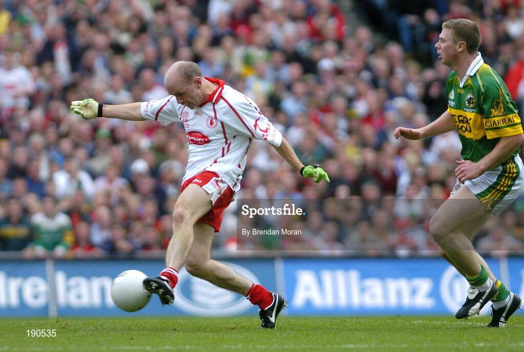 25 September 2005; Peter Canavan, Tyrone, shoots to scores his sides first goal despite the attentions of Tomas O Se, Kerry. Bank of Ireland All-Ireland Senior Football Championship Final, Kerry v Tyrone, Croke Park, Dublin. Picture credit; Brendan Moran / SPORTSFILE *** Local Caption *** Any photograph taken by SPORTSFILE during, or in connection with, the 2005 Bank of Ireland All-Ireland Senior Football Final which displays GAA logos or contains an image or part of an image of any GAA intellectual property, or, which contains images of a GAA player/players in their playing uniforms, may only be used for editorial and non-advertising purposes.  Use of photographs for advertising, as posters or for purchase separately is strictly prohibited unless prior written approval has been obtained from the Gaelic Athletic Association.