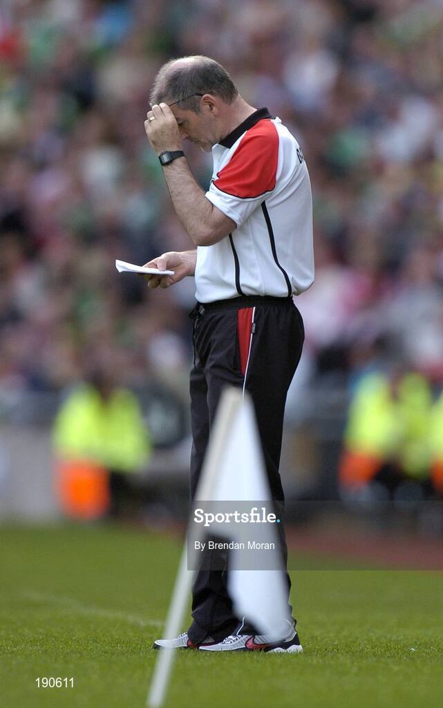 25 September 2005; Tyrone manager Mickey Harte checks his notes during the game. Bank of Ireland All-Ireland Senior Football Championship Final, Kerry v Tyrone, Croke Park, Dublin. Picture credit; Brendan Moran / SPORTSFILE *** Local Caption *** Any photograph taken by SPORTSFILE during, or in connection with, the 2005 Bank of Ireland All-Ireland Senior Football Final which displays GAA logos or contains an image or part of an image of any GAA intellectual property, or, which contains images of a GAA player/players in their playing uniforms, may only be used for editorial and non-advertising purposes.  Use of photographs for advertising, as posters or for purchase separately is strictly prohibited unless prior written approval has been obtained from the Gaelic Athletic Association.