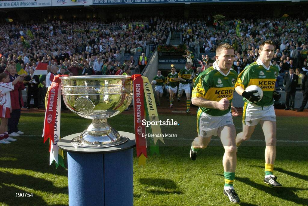 25 September 2005; Kerry players, including Dara O Cinneide, left, and William Kirby, make their way past the Sam Maguire Cup and out onto the pitch before the game. Bank of Ireland All-Ireland Senior Football Championship Final, Kerry v Tyrone, Croke Park, Dublin. Picture credit; Brendan Moran / SPORTSFILE *** Local Caption *** Any photograph taken by SPORTSFILE during, or in connection with, the 2005 Bank of Ireland All-Ireland Senior Football Final which displays GAA logos or contains an image or part of an image of any GAA intellectual property, or, which contains images of a GAA player/players in their playing uniforms, may only be used for editorial and non-advertising purposes.  Use of photographs for advertising, as posters or for purchase separately is strictly prohibited unless prior written approval has been obtained from the Gaelic Athletic Association.