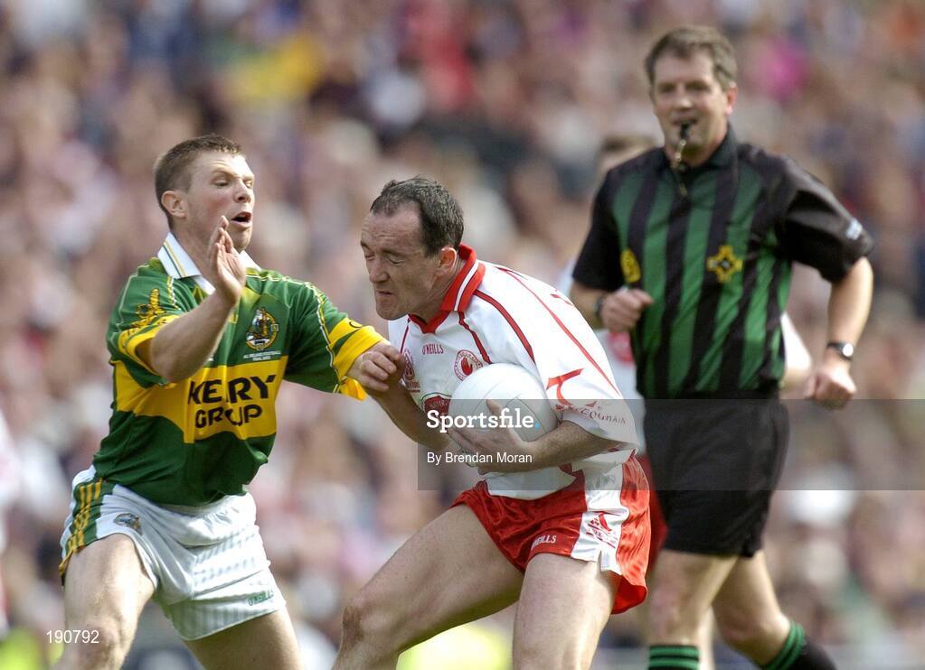 25 September 2005; Brian Dooher, Tyrone, is tackled by Tomas O Se, Kerry, watched by referee Michael Monahan. Bank of Ireland All-Ireland Senior Football Championship Final, Kerry v Tyrone, Croke Park, Dublin. Picture credit; Brendan Moran / SPORTSFILE *** Local Caption *** Any photograph taken by SPORTSFILE during, or in connection with, the 2005 Bank of Ireland All-Ireland Senior Football Final which displays GAA logos or contains an image or part of an image of any GAA intellectual property, or, which contains images of a GAA player/players in their playing uniforms, may only be used for editorial and non-advertising purposes.  Use of photographs for advertising, as posters or for purchase separately is strictly prohibited unless prior written approval has been obtained from the Gaelic Athletic Association.