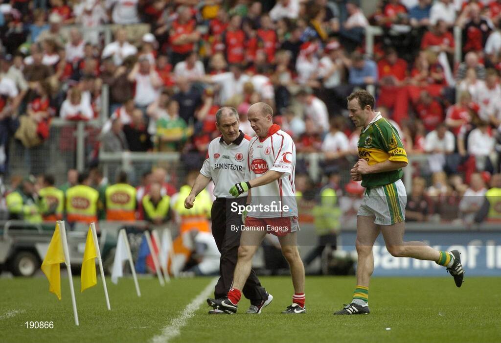 25 September 2005; Mickey Harte, Tyrone manager speaks to Tyrone's Peter Canavan as he makes his way off the pitch at half time as Kerry 's Seamus Moynihan runs by. Bank of Ireland All-Ireland Senior Football Championship Final, Kerry v Tyrone, Croke Park, Dublin. Picture credit; Damien Eagers/ SPORTSFILE *** Local Caption *** Any photograph taken by SPORTSFILE during, or in connection with, the 2005 Bank of Ireland All-Ireland Senior Football Final which displays GAA logos or contains an image or part of an image of any GAA intellectual property, or, which contains images of a GAA player/players in their playing uniforms, may only be used for editorial and non-advertising purposes.  Use of photographs for advertising, as posters or for purchase separately is strictly prohibited unless prior written approval has been obtained from the Gaelic Athletic Association.