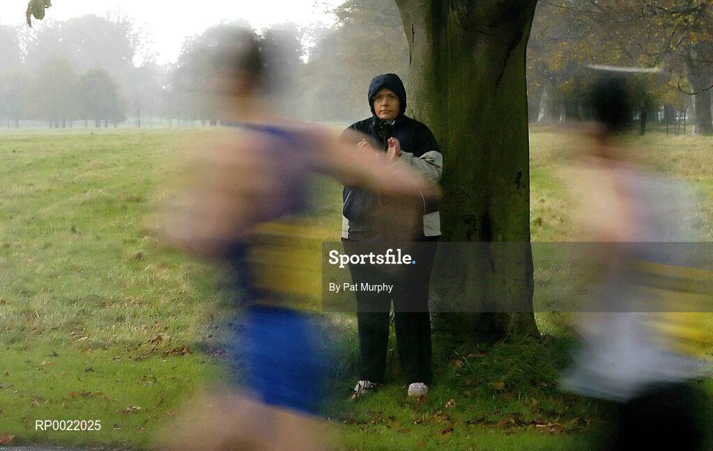31 October 2005; A woman shelters under a tree in the Phoenix Park while encouraging athletes during the 2005 adidas Dublin City Marathon. Picture credit: Pat Murphy / SPORTSFILE