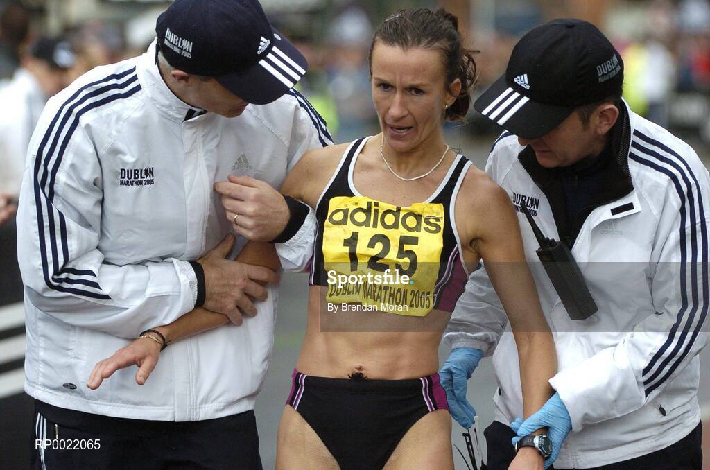 31 October 2005; Ireland's Pauline Curley is helped by race marshels after finishing the 2005 adidas Dublin City Marathon. Picture credit: Brendan Moran / SPORTSFILE